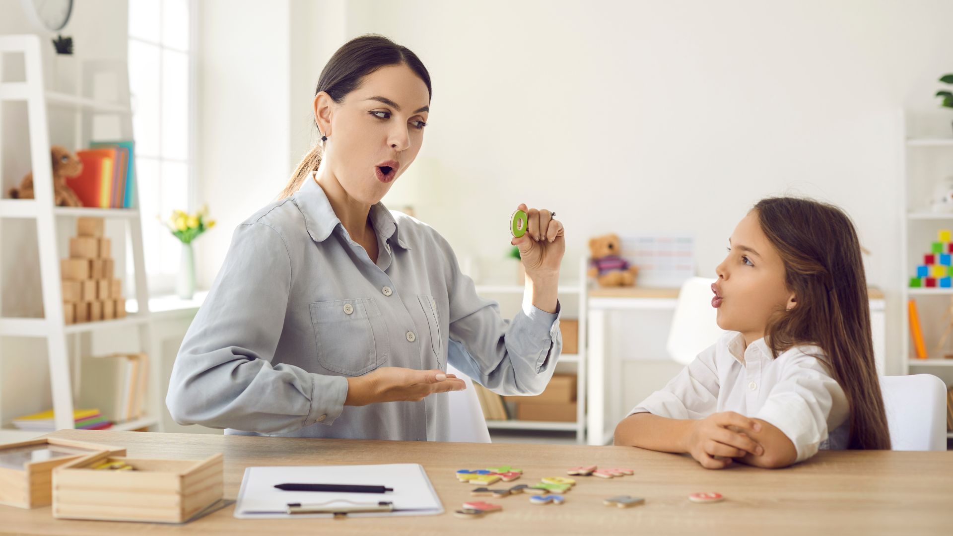 Speech therapist assisting a young girl with speech therapy.
