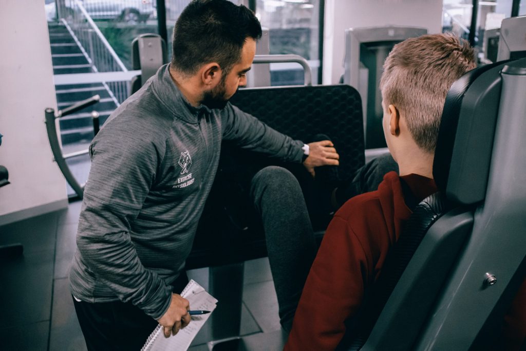 Exercise Physiology therapist guiding leg press exercise
