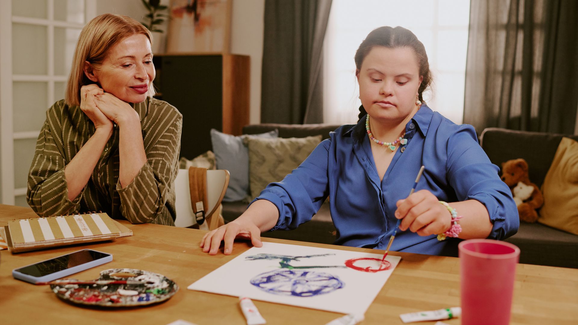 Early intervention: mentor supporting girl during painting